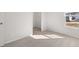 A bedroom with neutral carpet and access to a walk-in closet and window providing natural light at 6131 Knickerbocker St, Mableton, GA 30126