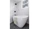 Modern bathroom with free-standing tub, marble accents, and dark tile floors at 1712 Evans Sw Dr, Atlanta, GA 30310
