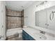 Bathroom featuring vanity with solid surface countertop and tiled shower-tub combination at 1915 North Rd, Snellville, GA 30078