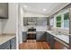 Bright kitchen boasts stainless steel oven, granite countertops, subway tile backsplash, and gray cabinets at 1915 North Rd, Snellville, GA 30078