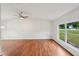 Open floor plan with hardwood floors, a ceiling fan, and large windows overlooking the yard at 1915 North Rd, Snellville, GA 30078