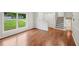Spacious room featuring hardwood floors, a large window, and stairs to the next floor at 1915 North Rd, Snellville, GA 30078