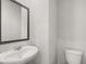 Elegant half bathroom featuring a sleek sink and toilet with bright lighting at 3042 Manor Hill Pl, Union City, GA 30291