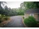 Wide driveway leading to a quaint home, bordered by lush landscaping and mature trees for added privacy at 329 Kelly Mill Rd, Cumming, GA 30040