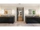 Bright bathroom featuring dual vanities, marble floors, and dark cabinets with modern lighting fixtures at 4132 Carmain Ne Dr, Atlanta, GA 30342
