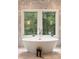 Serene bathroom with standalone tub, elegant fixtures, and scenic views through large windows at 4132 Carmain Ne Dr, Atlanta, GA 30342
