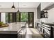 Bright kitchen with a marble island, sleek black cabinets, and double doors to the backyard at 4132 Carmain Ne Dr, Atlanta, GA 30342