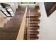 Overhead view of modern staircase with wood steps, glass railing, and contrasting metal supports creating a stylish design at 4132 Carmain Ne Dr, Atlanta, GA 30342