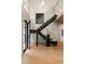 Contemporary staircase featuring wood steps, glass railing, and abundant natural light streaming through the arched front door at 4132 Carmain Ne Dr, Atlanta, GA 30342