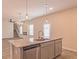 Open-concept kitchen island with stainless steel dishwasher and modern pendant lighting above at 250 Crabapple Rd, Mcdonough, GA 30253