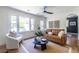 Sunlit living room with a comfortable leather sofa, accent chair, ceiling fan and large windows at 139 Sisson Ne Ave, Atlanta, GA 30317