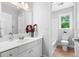 Bathroom with a large mirror, white cabinets, and wood-look flooring at 1661 Duxbury Nw Ln, Kennesaw, GA 30152
