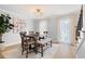 Elegant dining room with a modern chandelier, dining table with seating, light gray walls, and bright natural light at 1661 Duxbury Nw Ln, Kennesaw, GA 30152