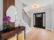 Modern entryway with wood-look floors, decorative mirror, console table, staircase with black railing, and contemporary lighting at 1661 Duxbury Nw Ln, Kennesaw, GA 30152