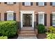 Inviting front entrance with a well-maintained walkway, brick steps, trimmed shrubbery, and a black front door with wreath at 1661 Duxbury Nw Ln, Kennesaw, GA 30152