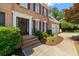 Inviting front entrance with a well-maintained walkway, brick steps, trimmed shrubbery, and a black front door with wreath at 1661 Duxbury Nw Ln, Kennesaw, GA 30152