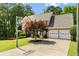 Traditional brick home with basketball hoop on the driveway, mature tree, and attached two-car garage at 1661 Duxbury Nw Ln, Kennesaw, GA 30152