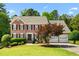 Charming two-story brick home featuring a landscaped yard, two-car garage, and classic architectural details on a sunny day at 1661 Duxbury Nw Ln, Kennesaw, GA 30152
