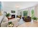 Cozy living room with plush seating, fireplace, modern lighting, and expansive windows overlooking a lush landscape at 1661 Duxbury Nw Ln, Kennesaw, GA 30152