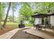 Backyard featuring a concrete patio with furniture, grill, lush grass, and trees at 2572 Beverly Hills Drive Dr, Chamblee, GA 30341