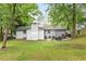 Spacious backyard with lush lawn, mature trees, and a patio with a grill and outdoor seating at 2572 Beverly Hills Drive Dr, Chamblee, GA 30341
