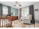 Bright Bedroom with a wooden crib, ceiling fan, rocking chair, and window with natural light at 2572 Beverly Hills Drive Dr, Chamblee, GA 30341
