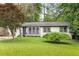 Charming single-story home featuring a well-maintained lawn, lush landscaping, and a welcoming entrance at 2572 Beverly Hills Drive Dr, Chamblee, GA 30341
