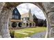 View of modern homes featuring unique architectural details and landscaping, framed by a stone archway at 380 2Nd St, Fayetteville, GA 30214