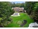 Expansive backyard featuring a pool, manicured lawn, putting green, and mature trees at 4560 Harris Trl, Atlanta, GA 30327