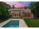 Backyard featuring a luxury home, a sparkling pool, a beautiful lawn, and lovely trees at 4560 Harris Trl, Atlanta, GA 30327