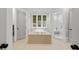 Bright bathroom featuring a soaking tub with deck, a walk-in shower, and white walls and trim at 4560 Harris Trl, Atlanta, GA 30327