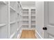 A walk-in closet/shelving unit with hardwood floors and an open white door at 4560 Harris Trl, Atlanta, GA 30327