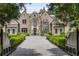 Stately brick and stone home with manicured landscaping, gated entrance, and circular driveway at 4560 Harris Trl, Atlanta, GA 30327