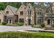 Elegant stone home with water feature, lush landscaping, and grand entrance, showcasing luxurious living at 4560 Harris Trl, Atlanta, GA 30327