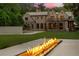 Beautiful backyard with a modern fire feature, expansive lawn, and a view of the home's rear exterior at 4560 Harris Trl, Atlanta, GA 30327