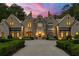 Stunning stone and brick home featuring a circular driveway, manicured landscaping, and elegant architectural details at 4560 Harris Trl, Atlanta, GA 30327