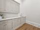 Well-lit laundry room featuring shaker cabinets, light countertops, and hardwood floors at 4560 Harris Trl, Atlanta, GA 30327