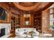 Sophisticated wood-paneled library with custom bookshelves, a cozy seating area, and a fireplace at 4560 Harris Trl, Atlanta, GA 30327