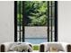 Bright living space with black framed windows offering a view of the pool and lush greenery beyond at 4560 Harris Trl, Atlanta, GA 30327