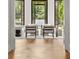 Bright living room with hardwood floors, modern furniture, and three sets of black framed glass doors at 4560 Harris Trl, Atlanta, GA 30327