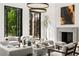 Elegant living room featuring stylish decor, fireplace, and floor to ceiling windows to the landscaped yard at 4560 Harris Trl, Atlanta, GA 30327