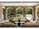 Covered patio with brick archways and cozy wicker furniture overlooking the yard at 4560 Harris Trl, Atlanta, GA 30327