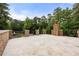 Large outdoor patio with stone flooring, brick accents and serene views at 4560 Harris Trl, Atlanta, GA 30327