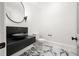 Modern powder room with black stone sink, marble floors, and stylish lighting at 4560 Harris Trl, Atlanta, GA 30327
