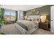This main bedroom features earth tone decor, a large bed, a bench seat near the window, and wood accents at 4954 Jatoba Rd # 72, Acworth, GA 30101