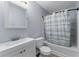 Clean bathroom with white fixtures, vanity, toilet, and a shower with a striped curtain at 16104 Waldrop Cv, Decatur, GA 30034