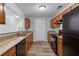 Functional kitchen with granite countertops, wood cabinets, and black appliances at 16104 Waldrop Cv, Decatur, GA 30034