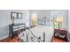 Inviting bedroom with a wrought iron bed frame, two windows, hardwood flooring, and neutral colored walls at 212 Brittany Ct, Duluth, GA 30096