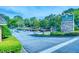 Community entrance featuring a stone sign for 'Hampton Arbors' surrounded by beautiful trees and landscaping at 212 Brittany Ct, Duluth, GA 30096