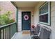 Inviting porch with chairs, wreath on door, and a view of the natural surroundings at 212 Brittany Ct, Duluth, GA 30096